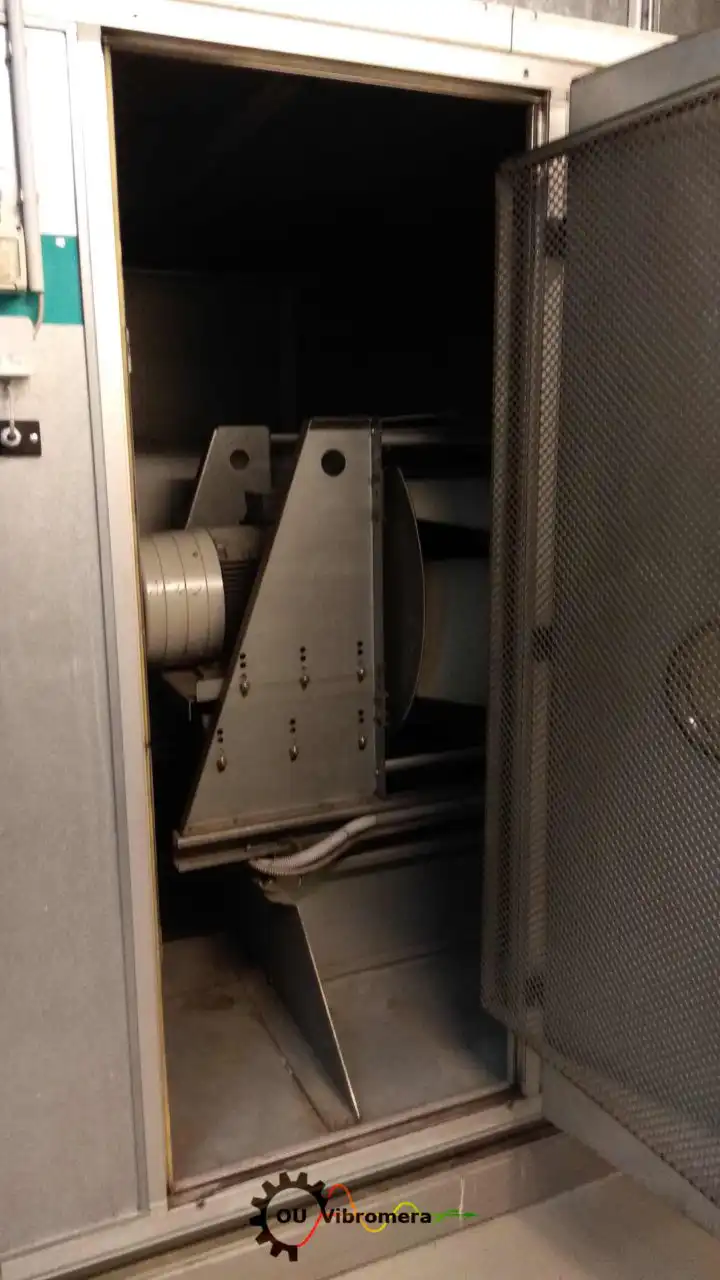 Vibromera rotor balancing machine with enclosed chamber showing rotor assembly, support brackets, and drive pulley system.