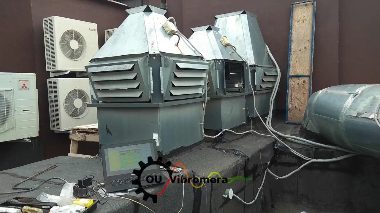 Vibromera rotor balancing setup with laptop displaying vibration analysis software, sensors attached to HVAC fan units via cables.