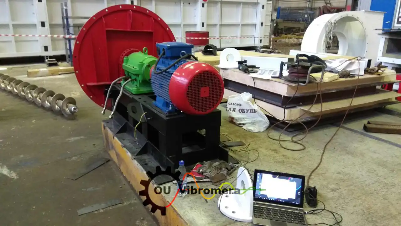 Conjunto de motor e ventilador industrial em suporte de teste com sistema de análise de vibração Vibromera, monitor de laptop e cabos de sensores.
