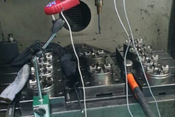 Installation d'équilibrage de broche CNC avec capteurs de vibrations, câbles et équipements de mesure fixés à la broche de la machine-outil.