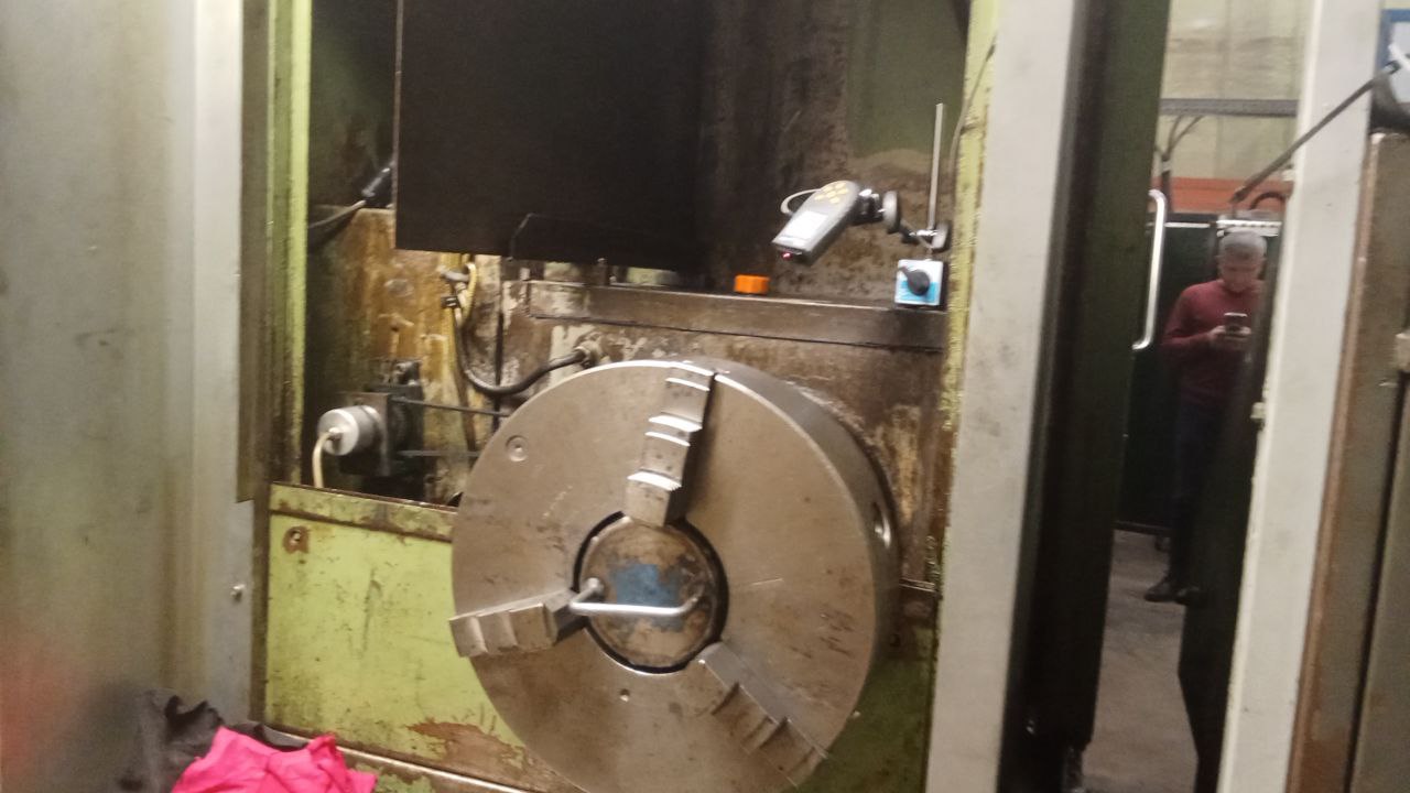 Laser tachometer on a magnetic stand aimed at a lathe chuck, vibration sensor on the headstock during rotor balancing